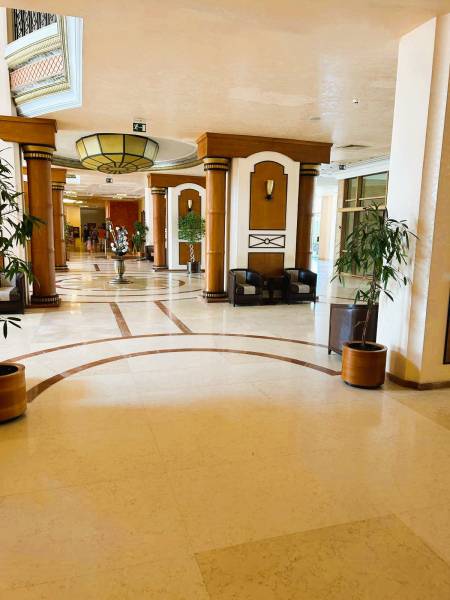 Štúdio DIT Majestic Beach Resort v 1. línií pri mori Bulharsko  - Elegantná hotelová chodba s dekoratívnymi stĺpmi a rastlinami v kvetináčoch.
