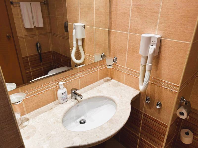 Štúdio DIT Majestic Beach Resort v 1. línií pri mori Bulharsko  - Kúpeľňa v 1-izbovom byte s umývadlom, fénom, mramorovou doskou a zrkadlom.