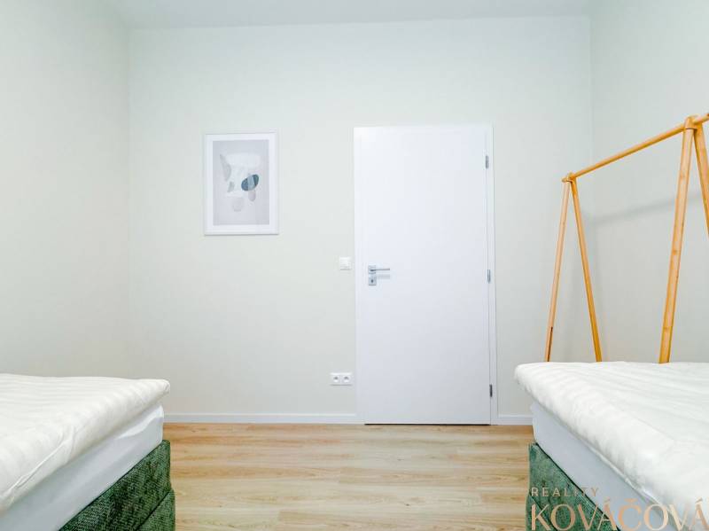 Na predaj 3 izbový byt s terasou, Trenčín, ul. Saratovská - Svetlá spálňa v 3-izbovom byte s podlahou s dreveným dekorom a minimalistickou výzdobou.