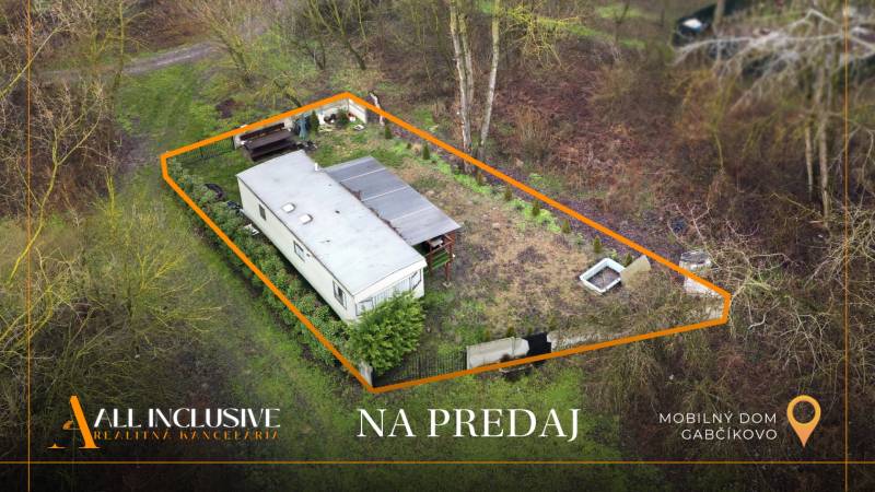 Na predaj 3-izb. mobilný dom pri Gabčíkovskom ramene - Mobilný dom v Gabčíkove, obklopený zeleňou a jasne vyznačeným pozemkom na predaj.