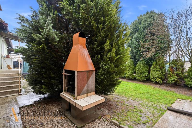 Na predaj 4-izb. rodinný dom s garážou, Okoč - Záhradný gril pri rodinnom dome na ulici Okoč vo Veľkom Mederi, obklopený zeleňou.