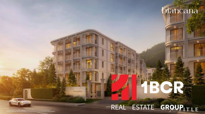 BIANCANA PHUKET - Výstavba bytov v Phuket, elegantná budova obklopená zeleňou za súmraku.