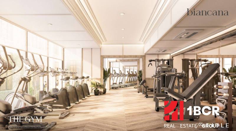 BIANCANA PHUKET - Interiérová telocvičňa s podlahou s dreveným dekorom a fitness vybavením v výstavbe bytov.