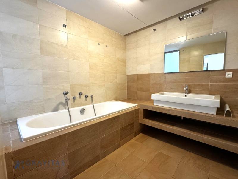 Na predaj veľký 2-izbový byt s terasou a wellness - Koliba - Kúpeľňa v 2-izbovom byte s vaňou, umývadlom a zrkadlom v neutrálnej farebnej schéme.