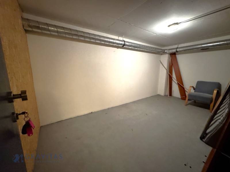 Na predaj veľký 2-izbový byt s terasou a wellness - Koliba - Prázdna miestnosť s kreslom a ventiláciou v 2-izbovom byte.