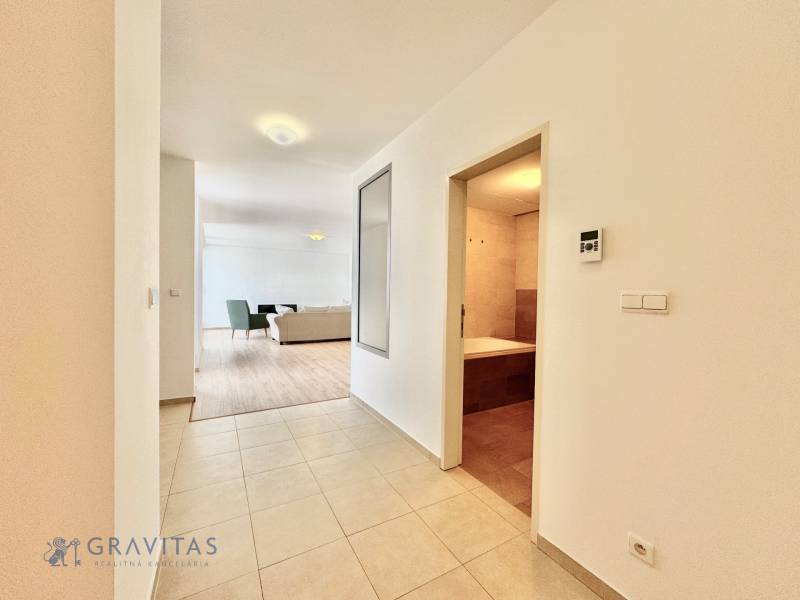 Na predaj veľký 2-izbový byt s terasou a wellness - Koliba - Interiér 2-izbového bytu s pohľadom na svetlú obývaciu izbu a kúpeľňu.