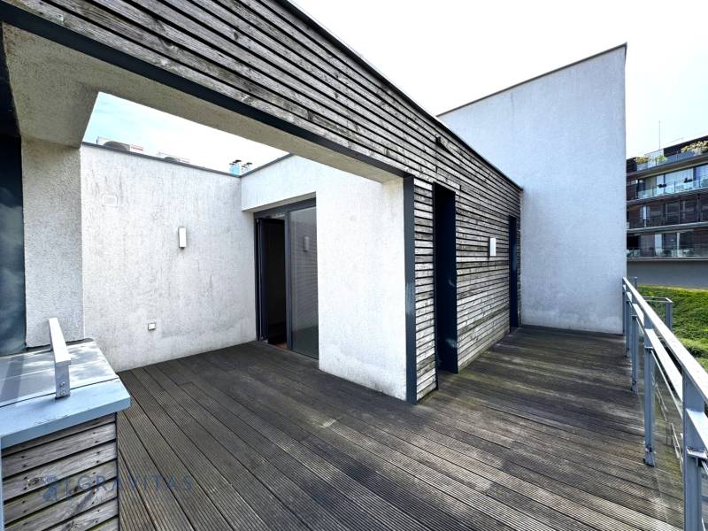 Na predaj veľký 2-izbový byt s terasou a wellness - Koliba - Balkónový priestor s drevenou podlahou a modernou architektúrou pri 2-izbovom byte.