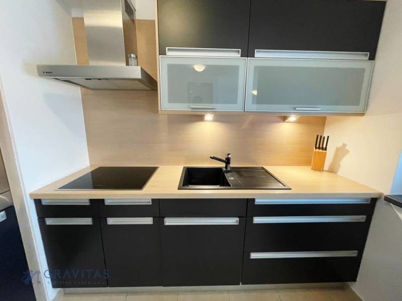 Na predaj veľký 2-izbový byt s terasou a wellness - Koliba - Kuchyňa s varnou doskou, drezom a skrinkami na ulici Tupého, 2-izbový byt.