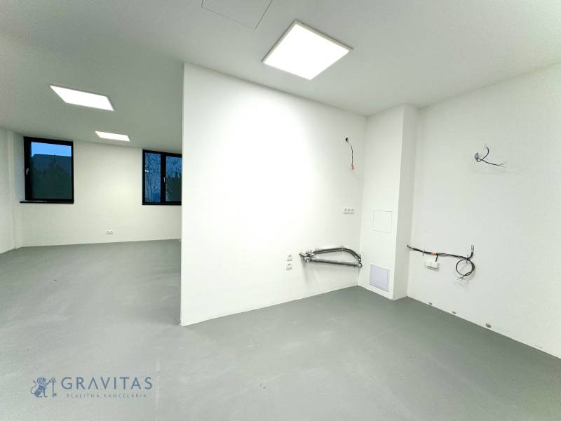Budova s 8 apartmánmi alebo medicínske centrum - Biela miestnosť na ulici Na varte v budove so sivou podlahou a čiernou dekoráciou.