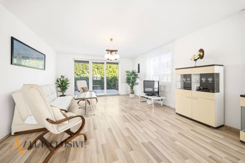 Na predaj 4-izb. rodinný dom s garážou, Kútniky - Svetlá obývačka s podlahou s dreveným dekorom, sedačka, kreslo a televízor.