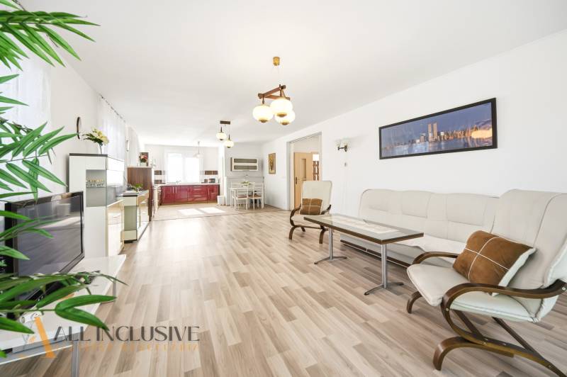 Na predaj 4-izb. rodinný dom s garážou, Kútniky - Obývačka v rodinnom dome s podlahou s dreveným dekorom a svetlým nábytkom.