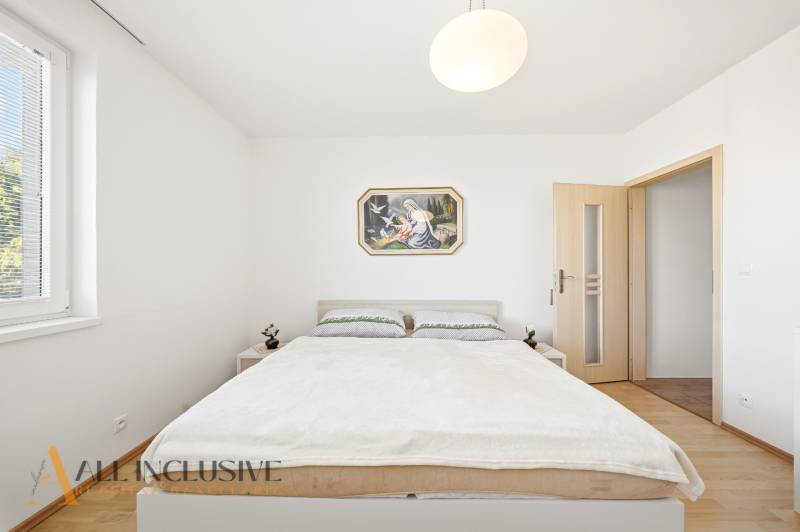 Na predaj 4-izb. rodinný dom s garážou, Kútniky - Spálňa v rodinnom dome s jednoduchým nábytkom a podlahou s dreveným dekorom.