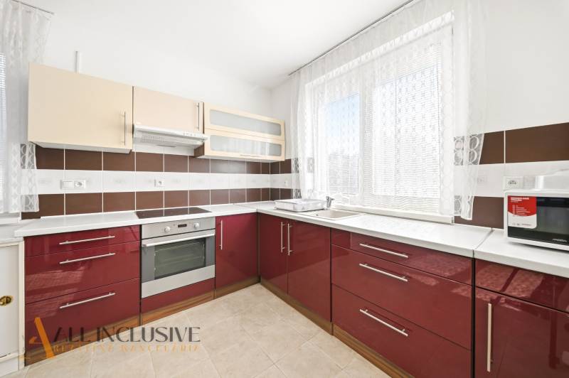 Na predaj 4-izb. rodinný dom s garážou, Kútniky - Kuchyňa v rodinnom dome s červenými skrinkami a spotrebičmi.