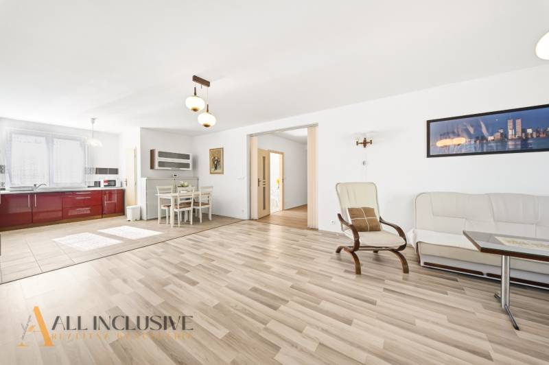 Na predaj 4-izb. rodinný dom s garážou, Kútniky - Svetlá obývacia miestnosť s kuchyňou, podlaha s dreveným dekorom, jedálenský kút.