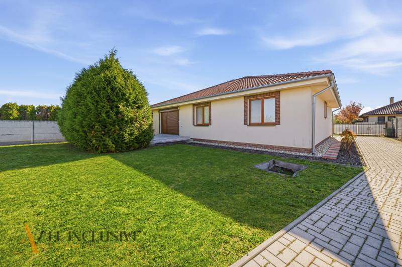 Na predaj 4-izb. rodinný dom s garážou, Kútniky - Rodinný dom v Kútnikoch s trávnikom, stromami a dlažbou.