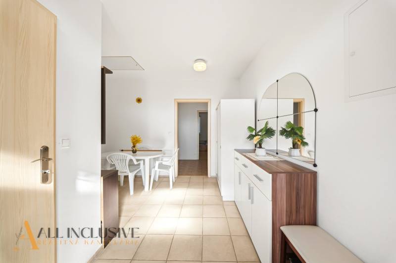 Na predaj 4-izb. rodinný dom s garážou, Kútniky - Interiér rodinného domu s bielym stolom a stoličkami, s veľkým zrkadlom na stene.