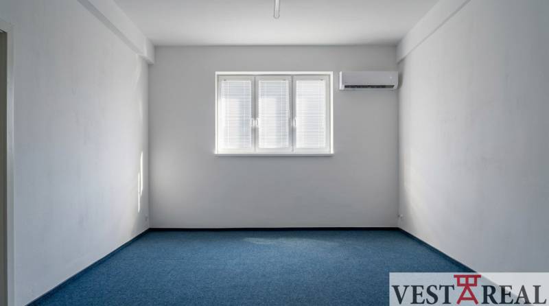 Prenájom klimatizovaná kancelária: 25 m2 a 42 m2 - Trnava Chovateľská - Kancelárie s modrým kobercom, bielymi stenami a klimatizáciou.