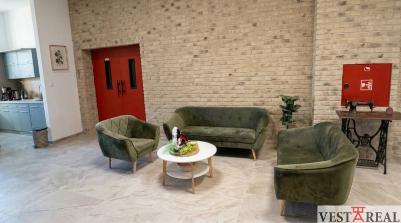 Prenájom klimatizovaná kancelária: 25 m2 a 42 m2 - Trnava Chovateľská - Priestranná kancelária s pohovkami, kuchynkou a tehlovou stenou.