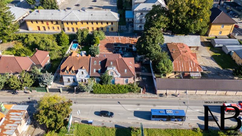 Exkluzívny predaj – veľkorysý rodinný dom pod Trenčianskym hradom - Ulica Kragujevských hrdinov v Trenčíne s rodinným domom, zeleňou a autobusom.