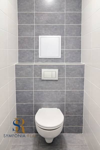 NOVOSTAVBA (2019) + PARKOVANIE | 2-izbový byt 69 m² – Bratislava - Toaleta s obkladom v 2-izbovom byte, sivo-biele dlaždice.