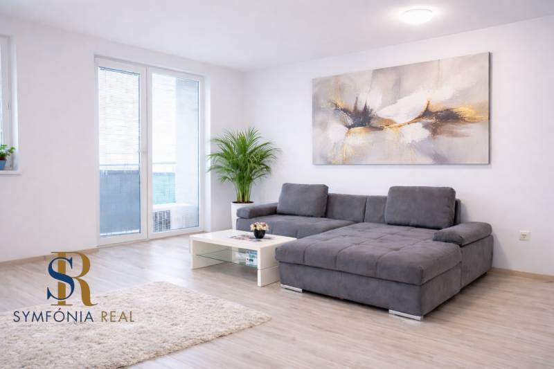 NOVOSTAVBA (2019) + PARKOVANIE | 2-izbový byt 69 m² – Bratislava - Obývačka v 2-izbovom byte ponúka pohodlnú sedačku a podlahu s dreveným dekorom.