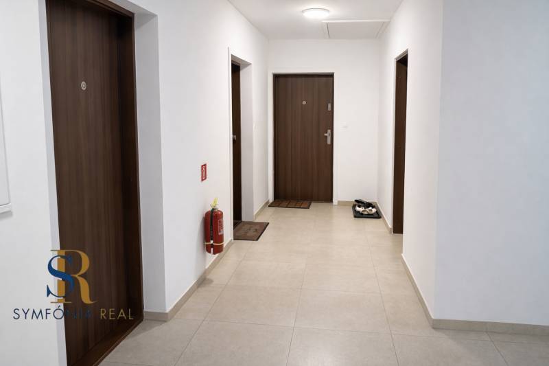 NOVOSTAVBA (2019) + PARKOVANIE | 2-izbový byt 69 m² – Bratislava - Chodba s viacerými dverami a hasiacim prístrojom, 2-izbový byt.