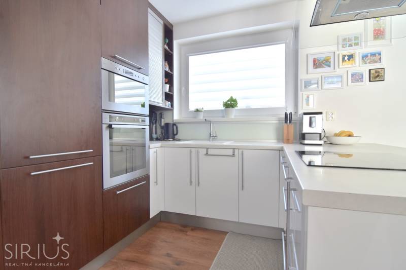 UHLISKÁ, 3-i byt, 80 m2 – zariadená novostavba s parkovaním v cene - Kuchyňa v 3-izbovom byte s podlahou s dreveným dekorom a veľkým oknom.