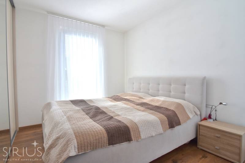 UHLISKÁ, 3-i byt, 80 m2 – zariadená novostavba s parkovaním v cene - Spálňa s posteľou a nočným stolíkom v 3-izbovom byte, podlaha s dreveným dekorom.