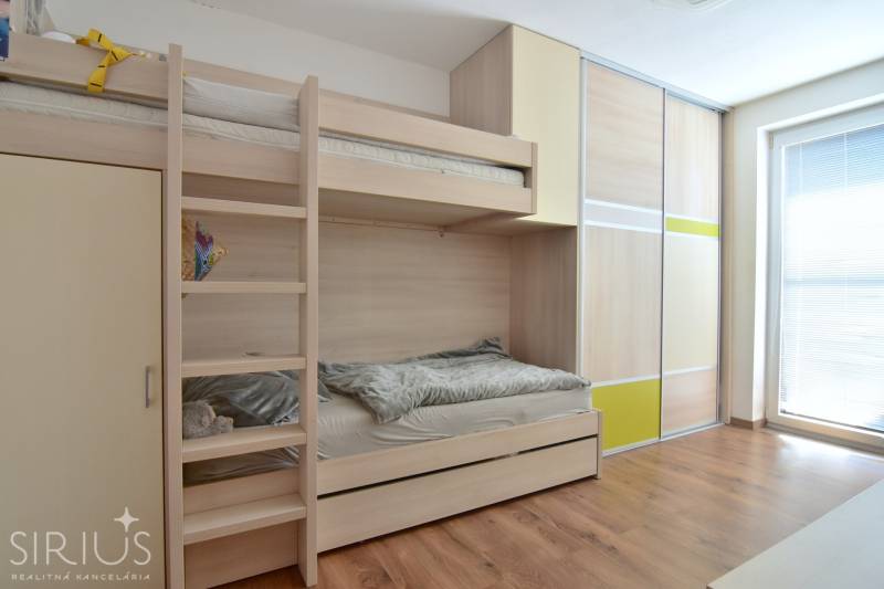 UHLISKÁ, 3-i byt, 80 m2 – zariadená novostavba s parkovaním v cene - Poschodová posteľ a vstavaná skriňa v izbe s podlahou s dreveným dekorom.