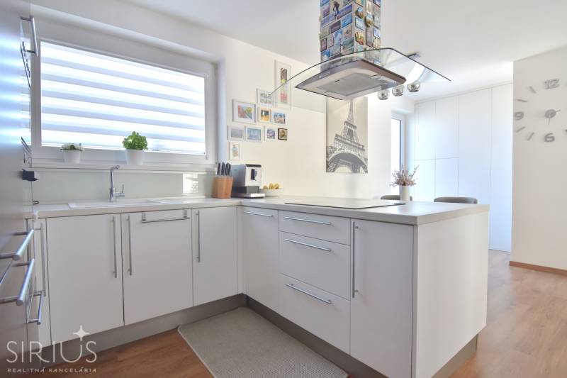 UHLISKÁ, 3-i byt, 80 m2 – zariadená novostavba s parkovaním v cene - Kuchyňa v 3-izbovom byte s dekorom Eiffelovej veže a podlahou s dreveným dekorom.