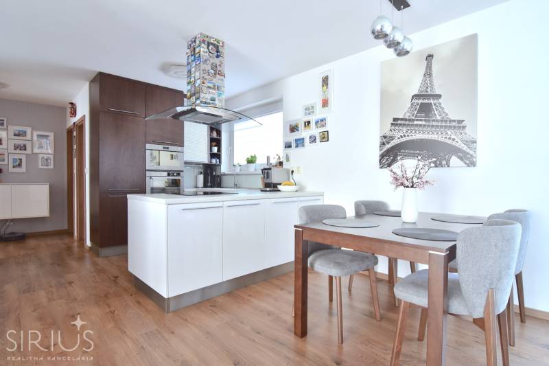 UHLISKÁ, 3-i byt, 80 m2 – zariadená novostavba s parkovaním v cene - Kuchyňa v 3-izbovom byte s podlahou s dreveným dekorom a jedálenským stolom.