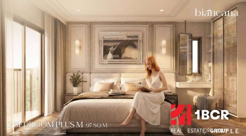 2 SPÁLŇOVÝ APARTMÁN BIANCANA PHUKET - Spálňa v 3-izbovom byte s posteľou, obrazom a ženou čítajúcou knihu.