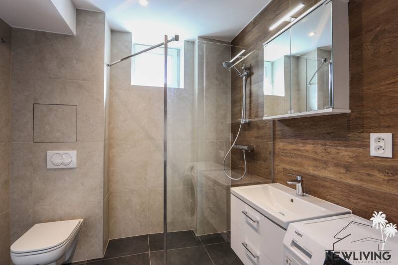 Na prenájom 3 izbový byt po kompletnej rekonštrukcií v Piešťanoch - Kúpeľňa v 3-izbovom byte s modernou sanitou a podlahou s dreveným dekorom.