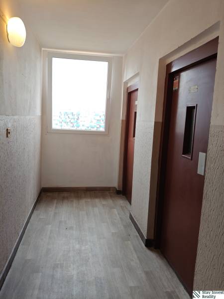 3-izbový byt s loggiou, výborná dispozícia, Jašíkova ulica Bratislava  - Chodba s výťahmi a podlahou s dreveným dekorom v 3-izbovom byte.