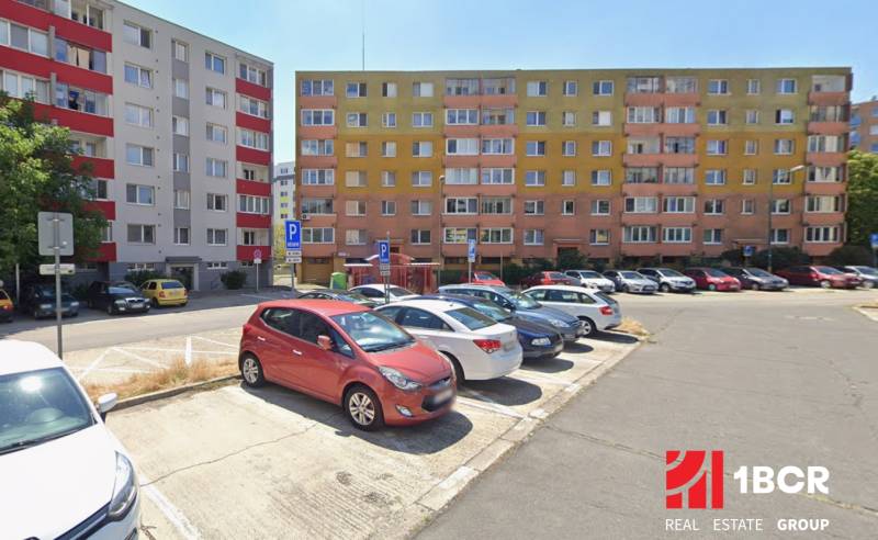4 IZB. BYT S LODŽIOU, PIVNICOU NA REKONŠTRUKCIU - GELNICKÁ, RAČA  - Parkovisko pred bytovkami v Bratislave - Rači s farebnými fasádami.