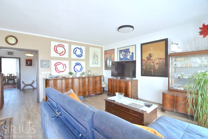 PRI VINOHRADOCH, 3-i byt s veľkými loggiami, 113 m2, RAČANY BIANCO - Obývačka v 3-izbovom byte s podlahou s dreveným dekorom a štýlovým nábytkom.