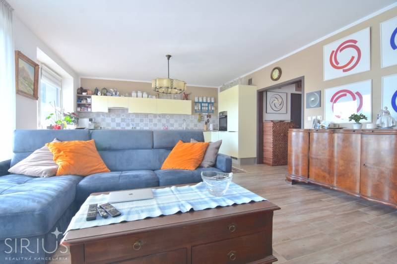 PRI VINOHRADOCH, 3-i byt s veľkými loggiami, 113 m2, RAČANY BIANCO - Obývačka s modrou sedačkou, podlaha s dreveným dekorom, 3-izbový byt.