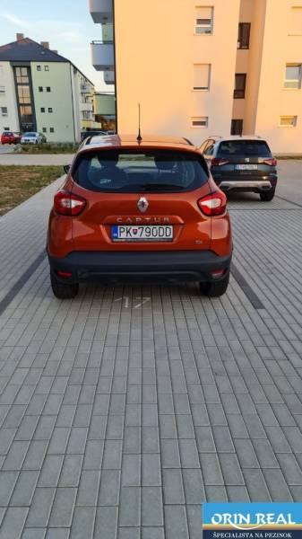 NOVÝ BYT S PREDZAHRADKOU A PARK. STÁTIM - Oranžový automobil Renault Captur zaparkovaný na dlaždenom priestore v Bratislava - Jarovce, Nyárfa.