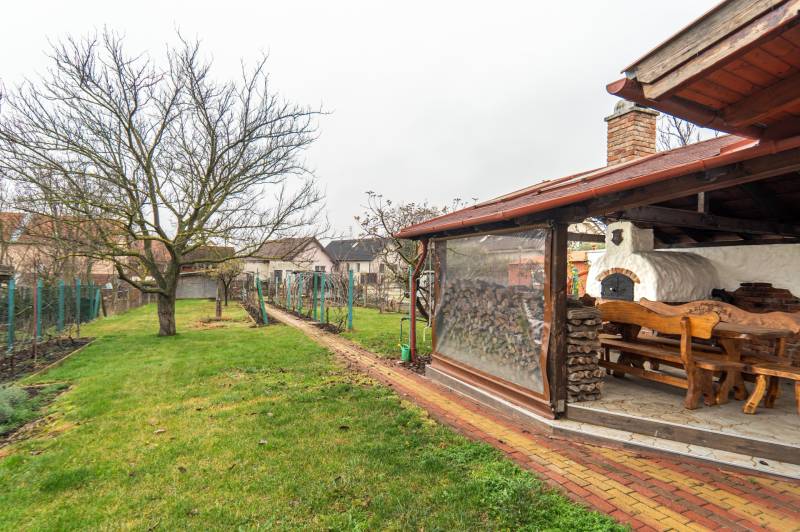 I Predaj štýlového tehlového domu v Rajke pri Bratislave - Záhrada rodinného domu na Jókai Mór v Rajke, vonkajšie posedenie pri peci.