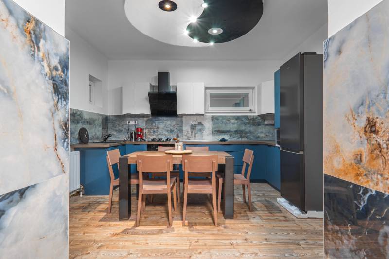 I Predaj štýlového tehlového domu v Rajke pri Bratislave - Kuchyňa v rodinnom dome s podlahou s dreveným dekorom a dekoratívnym obkladom stien.