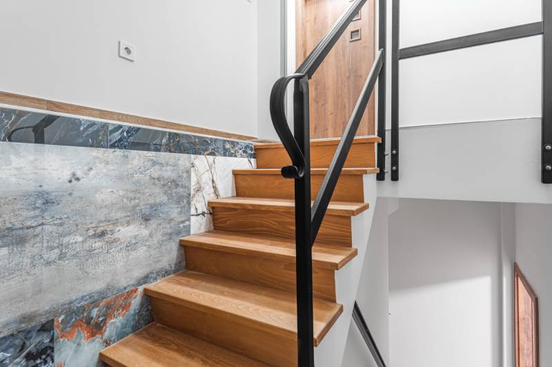 I Predaj štýlového tehlového domu v Rajke pri Bratislave - Schodisko s podlahou s dreveným dekorom v Rodinnom dome dopĺňa štýlový obklad stien.