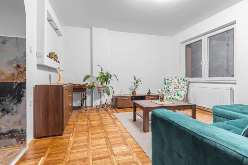 I Predaj štýlového tehlového domu v Rajke pri Bratislave - Obývacia izba v rodinnom dome s podlahou s dreveným dekorom a pohodlným nábytkom.