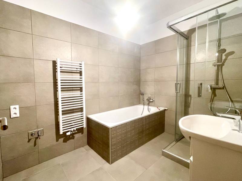 I Predaj 3i bytu v novostavbe v Rači - Kúpeľňa v 3-izbovom byte s vaňou, sprchovým kútom a rebríkovým radiátorom.