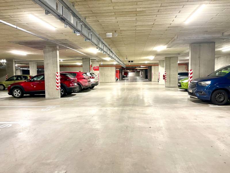 I Predaj 3i bytu v novostavbe v Rači - Podzemná garáž s autami a betónovými piliermi na Rudroffovej ulici v Bratislave - Rača.