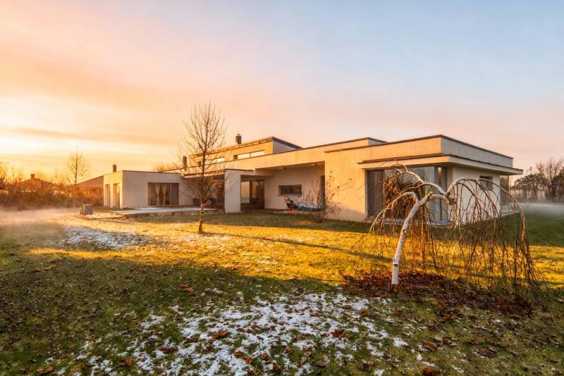 I PREDAJ moderná vila s bazénom a veľkým pozemkom - Rodinný dom na ulici Nagy Lajos király v Mosonmagyaróvári podvečernom svetle s trávnikom.