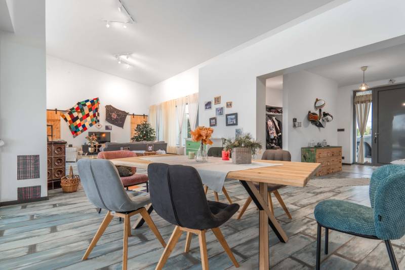 I PREDAJ moderná vila s bazénom a veľkým pozemkom - Interiér vily s podlahou s dreveným dekorom, závesmi a dreveným stolom, zdobené stoličky.