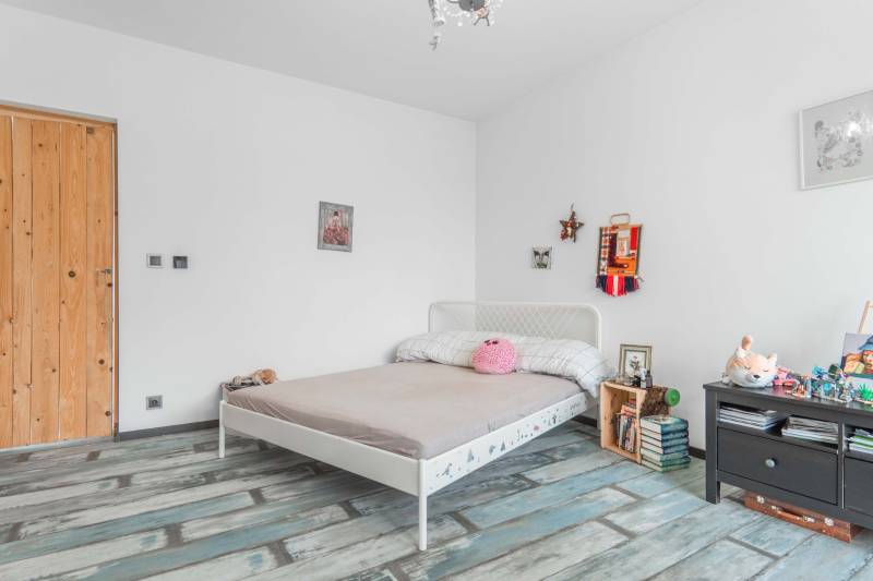 I PREDAJ moderná vila s bazénom a veľkým pozemkom - Svetlá spálňa s podlahou s dreveným dekorom, posteľou a dekoráciami vo vile.