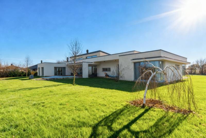 I PREDAJ moderná vila s bazénom a veľkým pozemkom - Rodinný dom na ulici Nagy Lajos király v Mosonmagyaróvári s upravenou záhradou a bezlistým stromom.