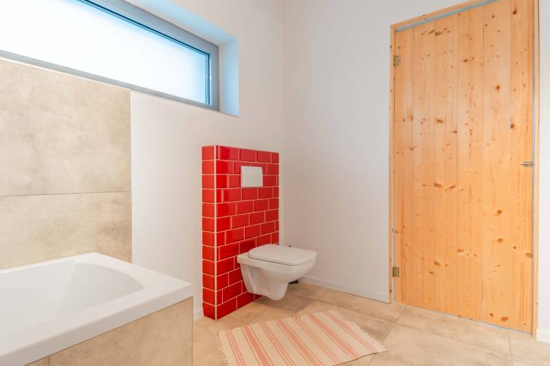 I PREDAJ moderná vila s bazénom a veľkým pozemkom - Kúpeľňa v rodinnom dome s červenými obkladmi a drevenými dverami.
