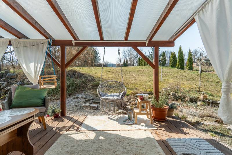 Stavebný pozemok 8 500 m² s podnikateľským potenciálom - Krytá terasa so záhradným nábytkom s výhľadom na pozemky - bývanie v Dolnom Lopašove.